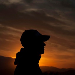 Ali, de profil devant un coucher de soleil